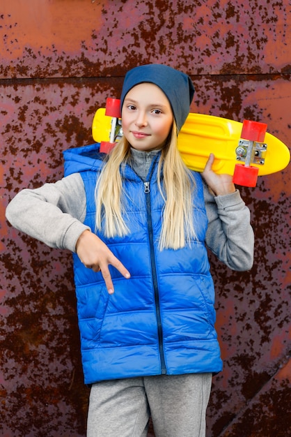 Chica posando con patineta al aire libre