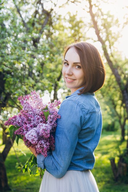 Chica posando con un ramo de lilas