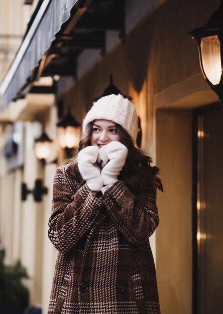 Chica positiva con gorro de invierno y mitones