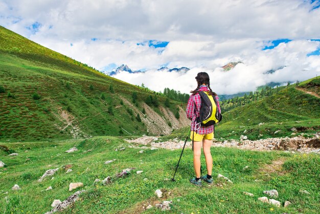 Chica en una pradera de montaña durante un paseo