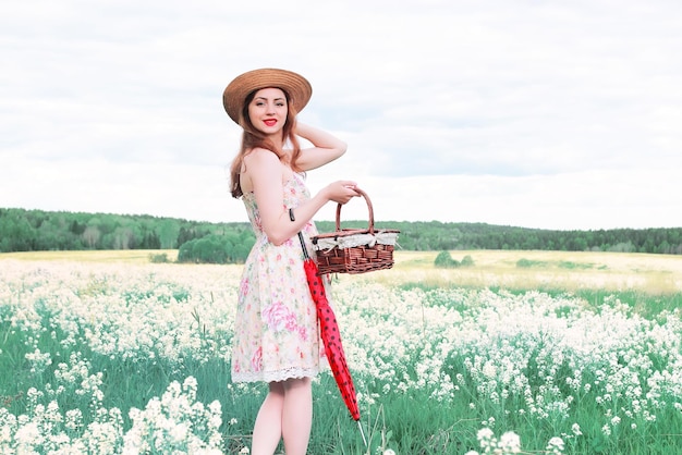 Chica en un prado de verano con flor blanca en día nublado