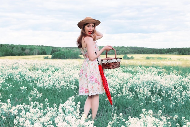 Chica en un prado de verano con flor blanca en día nublado