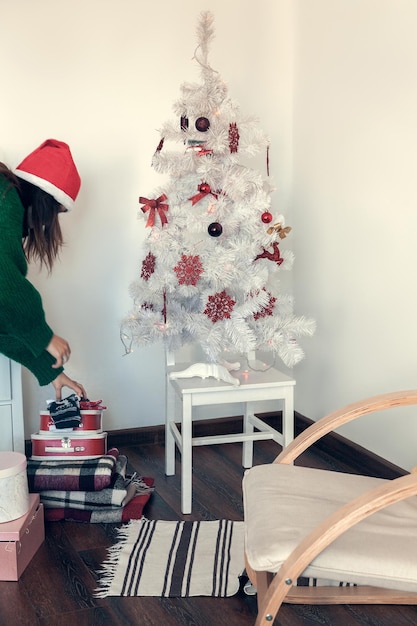 Chica preparándose para la navidad en el fondo del árbol de navidad