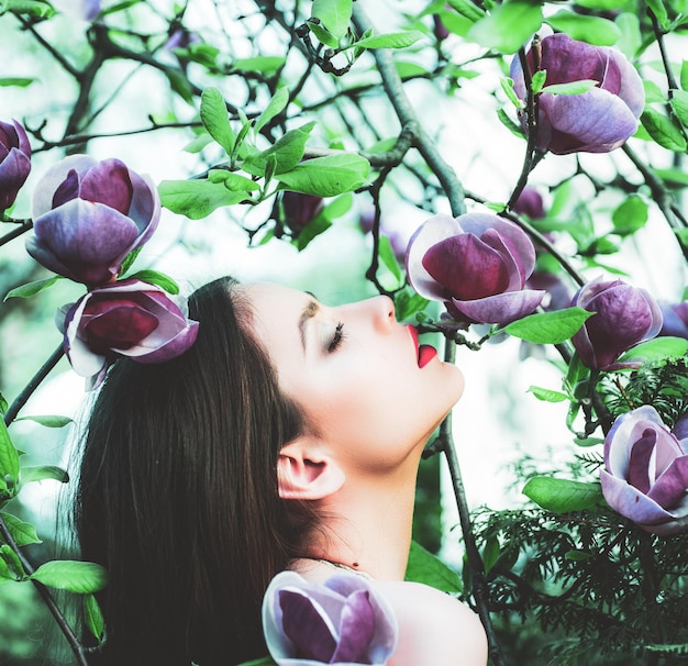 Chica de primavera de moda en el fondo de flores de magnolia de primavera mujer en el fondo de flor de primavera