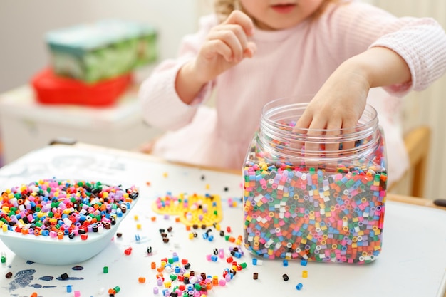 Chica de primer plano jugando Hama Beads