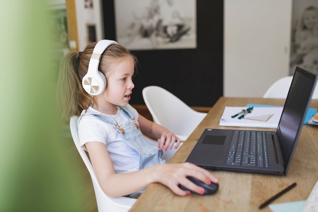 Chica de primer plano usando una computadora portátil en casa