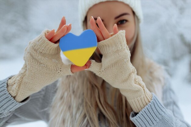 La chica del primer tiene un corazón nevado frente a ella con guantes