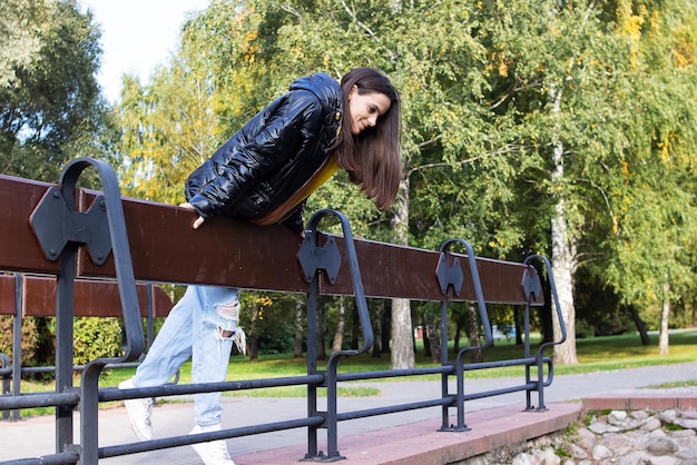 Chica en el puente en el parque de otoño