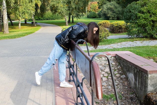 Chica en el puente en el parque de otoño