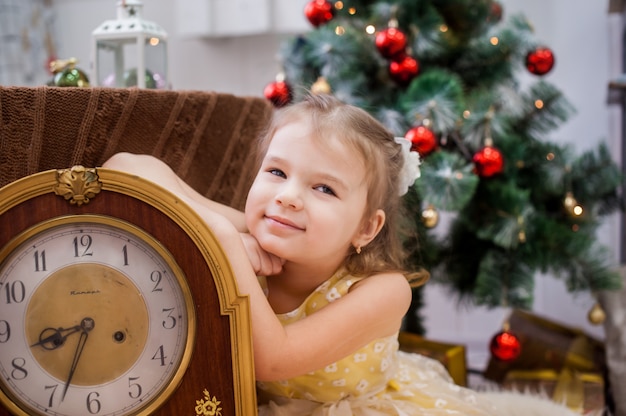 Chica puso su cabeza sobre sus manos, sobre el árbol de Navidad