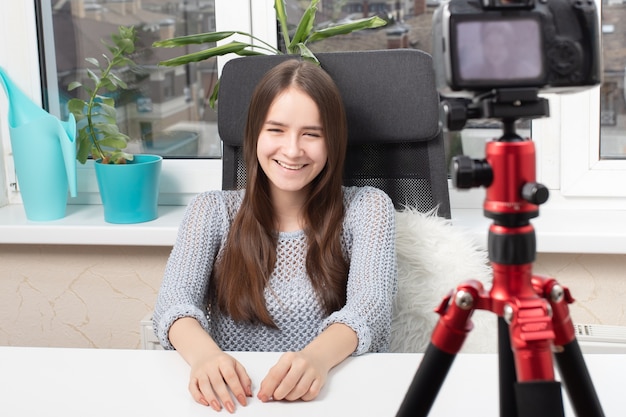 La chica que la bloguera realiza un video blog, se comunica con la audiencia.