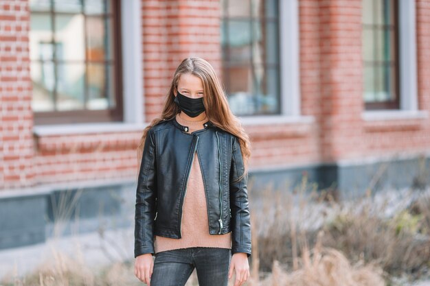 Chica que llevaba una máscara sobre un fondo de un edificio moderno