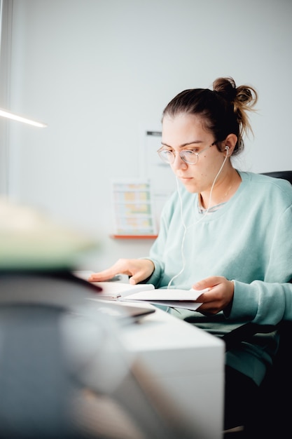 Chica que trabaja en la computadora portátil desde casa o estudiante que estudia desde casa o autónomo. Trabajo en línea, trabajo de escritorio temprano en la mañana, oficina en casa