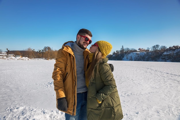 La chica quiere besar al chico en un día soleado de invierno.