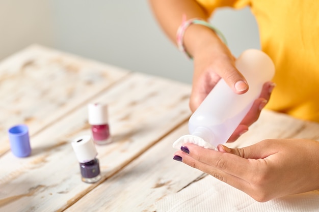 Foto chica quitando el esmalte de uñas, no se muestran caras