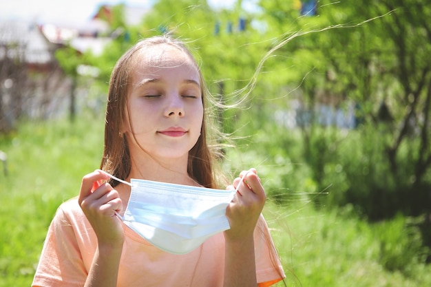 Chica quitándose su mascarilla médica