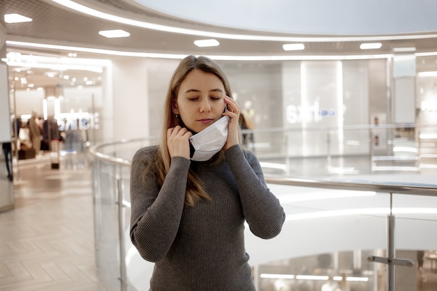 Chica quitar la máscara de la cara en el centro comercial.