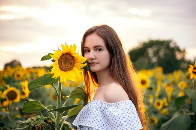 Chica con ramo amarillo de campo floreciente de girasol