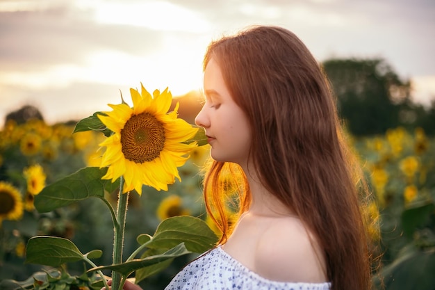 Chica con ramo amarillo de campo floreciente de girasol