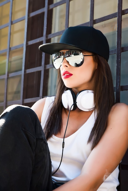 Foto chica rapera con auriculares en una ciudad europea