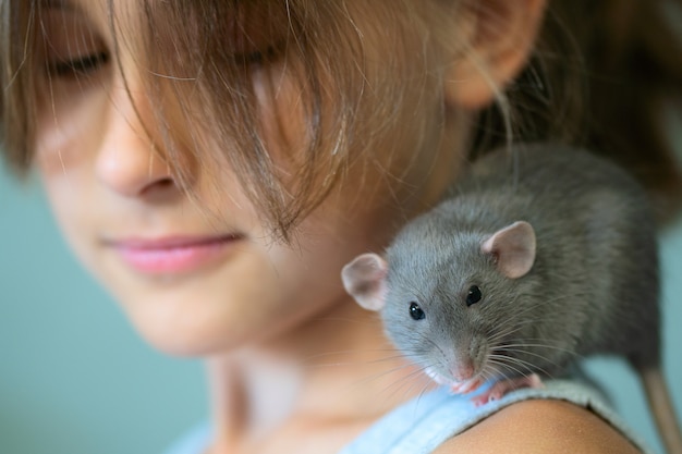 Foto chica con una rata en el hombro. mascota favorita.