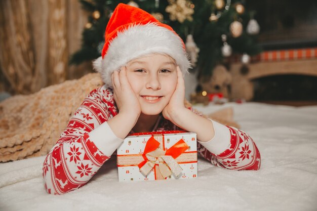 Chica con un regalo en el árbol de Navidad