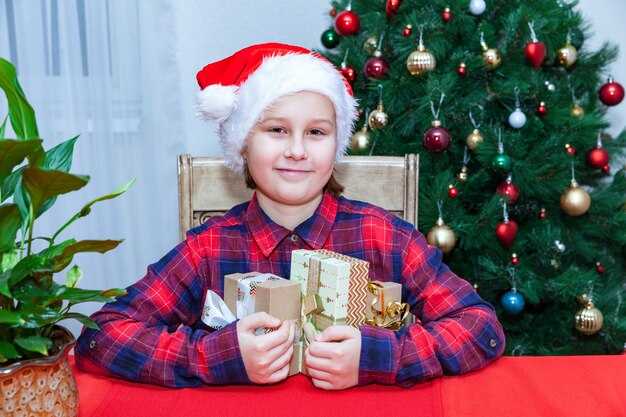 Chica con regalos en el fondo del árbol de Navidad