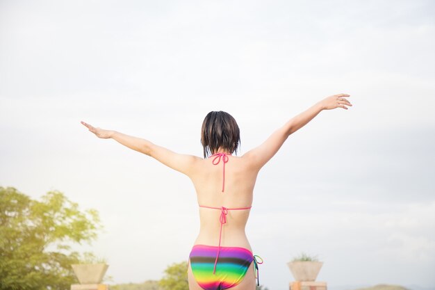 Chica relajante en la piscina. Joven mujer asiática disfrutando en el spa de la piscina en el hotel resort