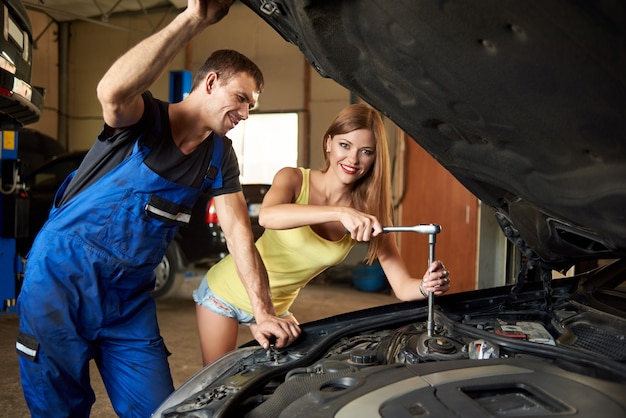 Chica reparando el auto con una llave