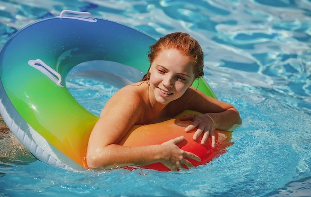 Chica de resort de piscina de concepto de vacaciones de verano en colchón inflable día caluroso de verano