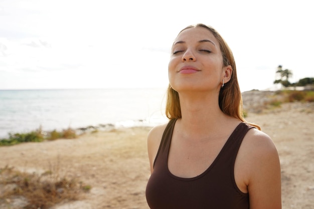 Chica de respiración de belleza relajada con los ojos cerrados en la playa Espacio de copia