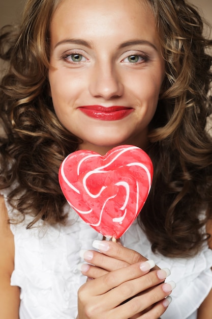 Foto chica rizada muy feliz con una paleta en la mano