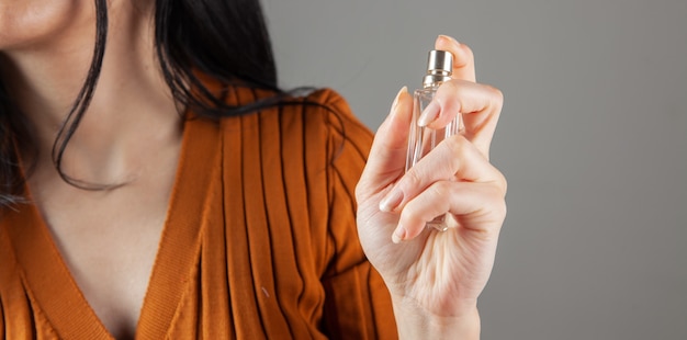 Chica rocía perfume sobre sí misma