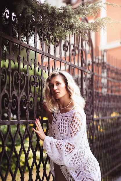 Chica romantik positiva en el centro de la ciudad foto de una mujer rubia increíble con maquillaje natural que se ve feliz caminando al aire libre