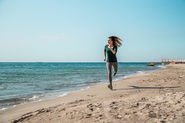 Chica en ropa deportiva a lo largo del mar