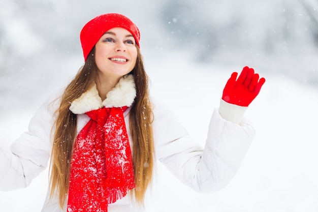 Chica en ropa de invierno con hermoso maquillaje agitando su mano