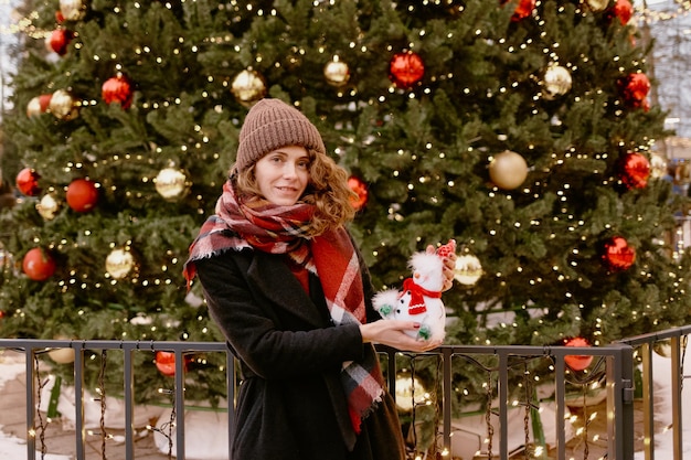 Foto chica con ropa de invierno en el mercado navideño. mujer al aire libre.