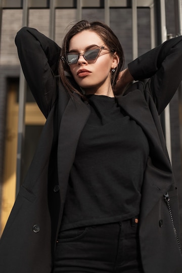 Chica en ropa juvenil casual negra de moda. mujer blazer de moda en elegante camiseta negra se encuentra en calle en la ciudad. traje negro vintage para mujer.