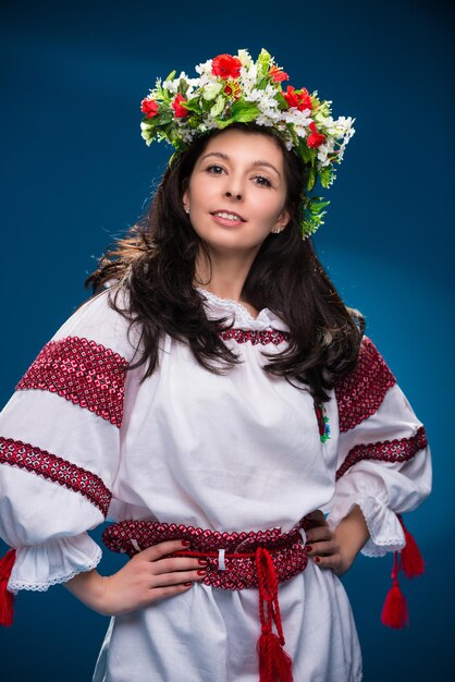 Una chica con ropa nacional de una mujer ucraniana de fondo azul.