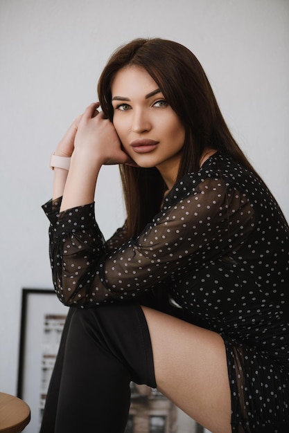 Chica en ropa oscura sentada con los brazos cruzados