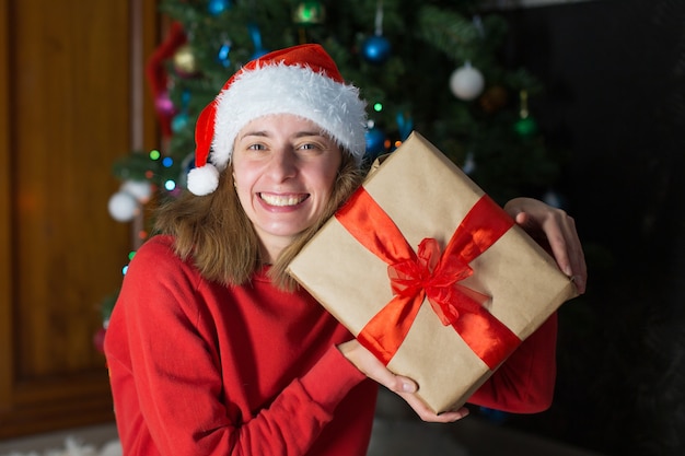 Chica en ropa roja despliega regalos de año nuevo. el concepto de celebrar la medianoche navideña.