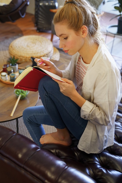 Chica rubia atenta mirando sus notas, sumida en sus pensamientos