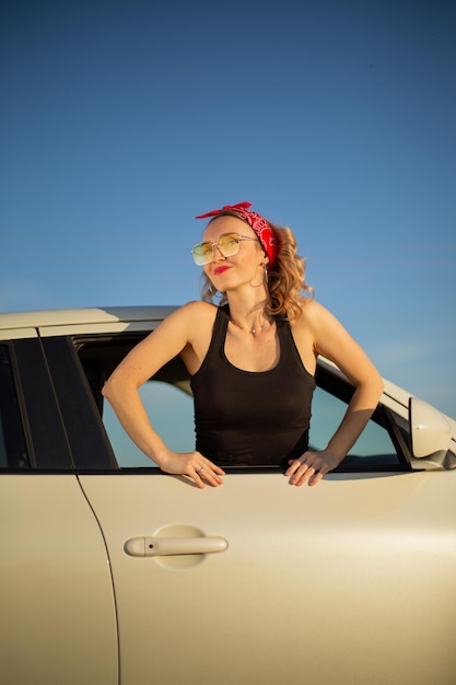 Chica rubia en un auto alquilado en un viaje