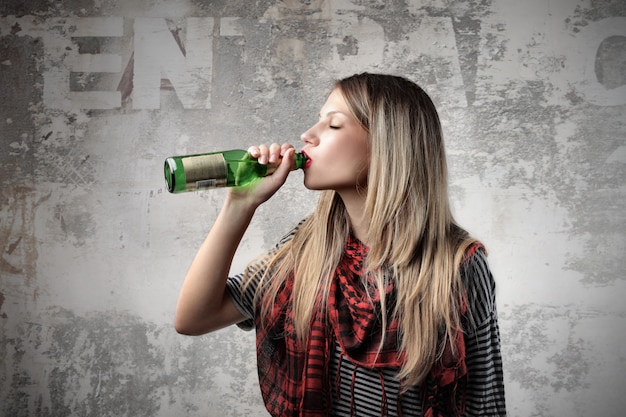 Chica rubia bebiendo cerveza