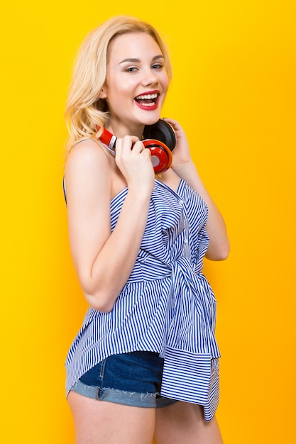 Chica rubia en blusa azul a rayas con auriculares