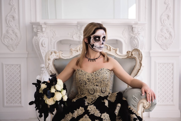 Chica rubia con calavera de azúcar hacer. Día de muertos o halloween