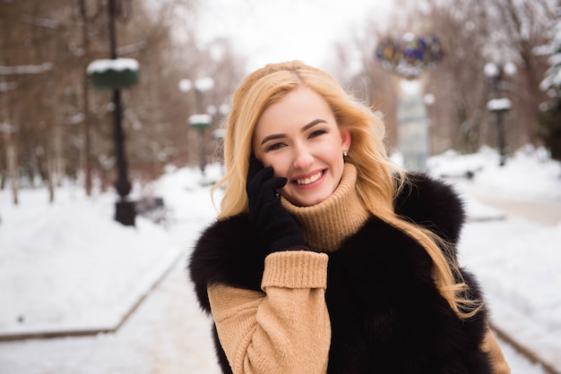 Chica rubia caminando en la calle en invierno