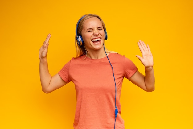 Chica rubia escucha música con auriculares