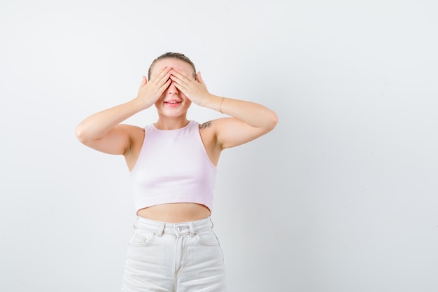 Chica rubia está cerrando los ojos sobre fondo blanco.