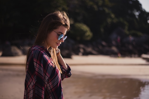 chica rubia con gafas de sol en la playa